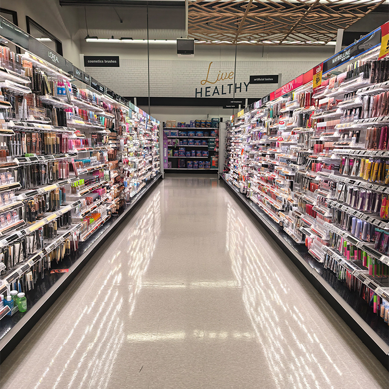 Retail cosmetics aisle with illuminated shelving on both sides