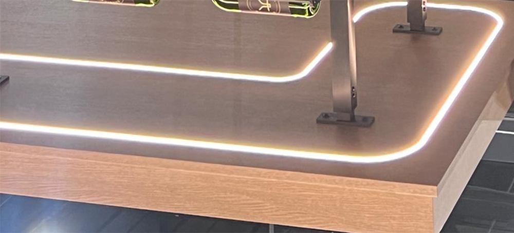 Illuminated LED neon following rounded corners on a wooden display panel